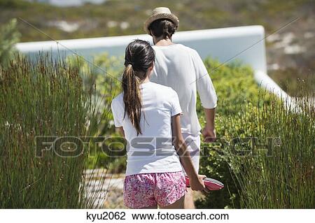 Stock Image - Couple walking in a garden. Fotosearch