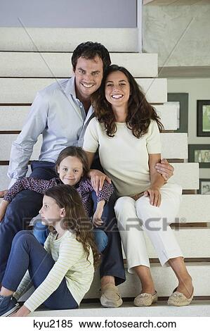 Stock Photography - Couple with their children sitting on steps. Fotosearch