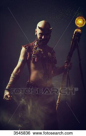 Creature in the dark holding a magic stick View Large Photo Image Stock Photograph - Creature in the dark holding a magic stick. Fotosearch