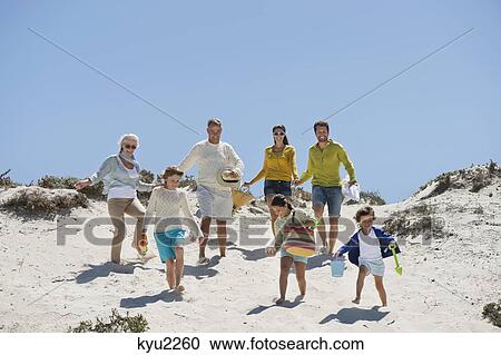 Stock Image - Family walking on the beach. Fotosearch