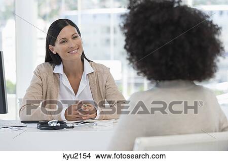 Female doctor discussing with a patient View Large Photo Image Picture - Female doctor discussing with a patient. Fotosearch
