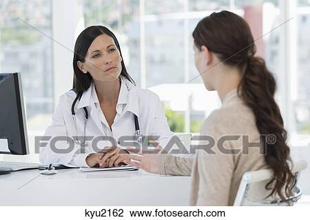 Female doctor discussing with a patient View Large Photo Image Stock Image - Female doctor discussing with a patient. Fotosearch