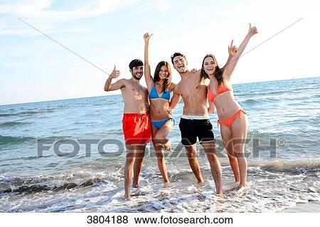 France, 2 young couples friends posing in front of the sea doing the arms in the air making the sign of the success and the happiness. View Large Photo Image Stock Photo - France, 2 young couples friends posing in front of the sea doing the arms in the air making the sign of the success and the happiness.. Fotosearch