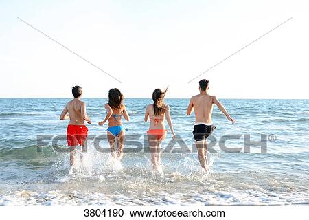 France, 4 young people of back run on entering the sea to go bathe. View Large Photo Image Stock Image - France, 4 young people of back run on entering the sea to go bathe.. Fotosearch