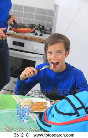 Stock Image - France, chid eating breaded fish. Fotosearch