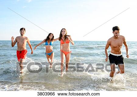 France, four young adults running in the sea in swimsuit. View Large Photo Image Stock Photograph - France, four young adults running in the sea in swimsuit.. Fotosearch