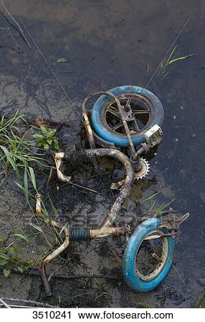 Stock Image - France, Limousin, broken kid bike abandonned in the river. Fotosearch