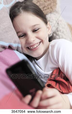 France, little girl and smartphone in her bedroom View Large Photo Image Picture - France, little girl and smartphone in her bedroom. Fotosearch
