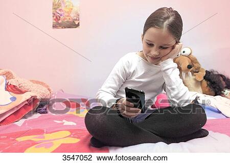 France, little girl and smartphone in her bedroom View Large Photo Image Stock Image - France, little girl and smartphone in her bedroom. Fotosearch