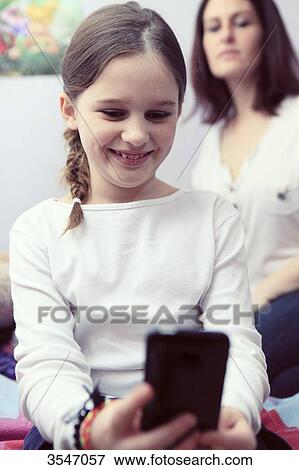 France, little girl and smartphone in her bedroom View Large Photo Image Stock Photo - France, little girl and smartphone in her bedroom. Fotosearch