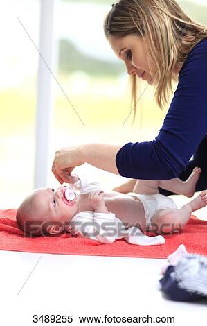 Stock Photography - France, mother changing her baby. Fotosearch