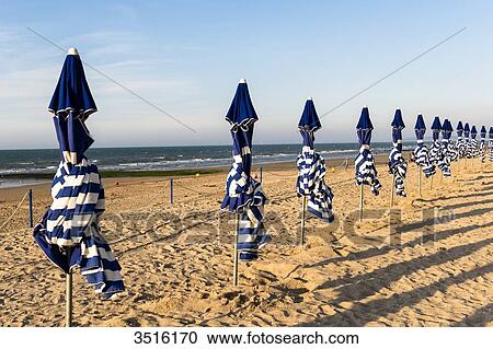 France, Normandy, beach umbrellas at the end of a summer day on the beach of Cabourg View Large Photo Image Stock Image - France, Normandy, beach umbrellas at the end of a summer day on the beach of Cabourg. Fotosearch