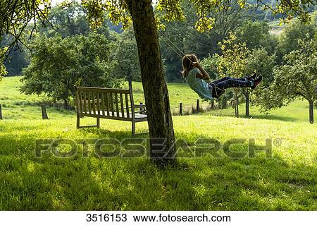 France, Normandy, little girl enjoying a go on a swing in a beautiful countryside garden View Large Photo Image Stock Image - France, Normandy, little girl enjoying a go on a swing in a beautiful countryside garden. Fotosearch