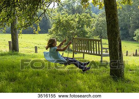 France, Normandy, little girl enjoying a go on a swing in a beautiful countryside garden View Large Photo Image Stock Photography - France, Normandy, little girl enjoying a go on a swing in a beautiful countryside garden. Fotosearch