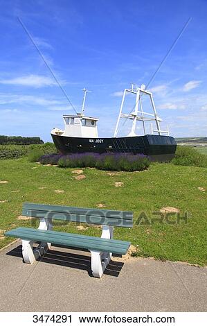 Stock Image - France, Northern France, Le Touquet. Boat on lawn behind a bench. Fotosearch