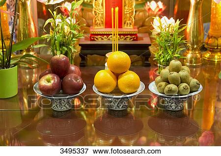 Stock Photo - France. Paris 13th district. Parisian Chinatown. District of the Olympiades. Offerings in front of the altar of the Buddhist temple of the Teochew association in France.. Fotosearch