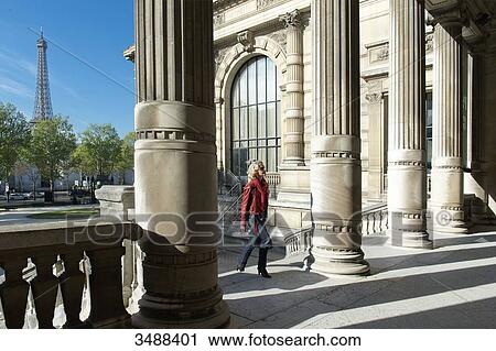 Stock Image - France. Paris 16th district. Parisian woman between the columns of the Galliera palace, the museum of the fashion of the City of Paris. Architect: Leon Ginain (1894).. Fotosearch