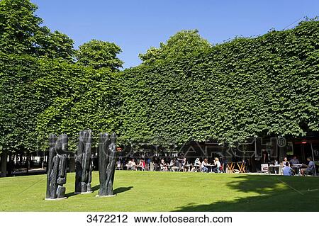 France, Paris. 1st arrondissement. Jardin des Tuileries. Sculpture Characters III by Stephen Martin. Tourists outside a restaurant in the background. View Large Photo Image Stock Image - France, Paris. 1st arrondissement. Jardin des Tuileries. Sculpture Characters III by Stephen Martin. Tourists outside a restaurant in the background.. Fotosearch