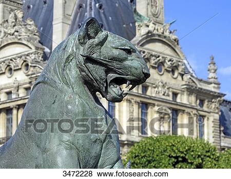 Stock Photo - France, Paris. 1st arrondissement. Jardin des Tuileries. Sculpture Tiger slaying a crocodile by Auguste Nicolas Cain. The Louvre Museum in the background.. Fotosearch