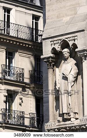 Stock Photo - France, Paris. 4th arrondissement. Ile de la Cite. Sculpture on the facade of Notre Dame Cathedral. Building in the background.. Fotosearch