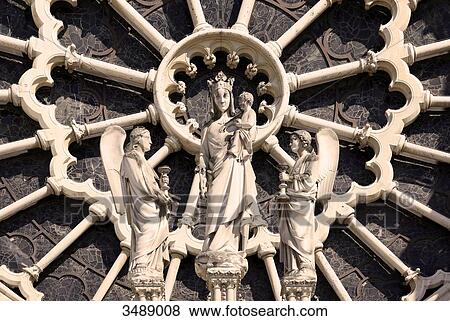 Stock Photo - France, Paris, 4th arrondissement, Notre Dame Cathedral, closeup of the western rose and the sculpture of the Virgin. Fotosearch