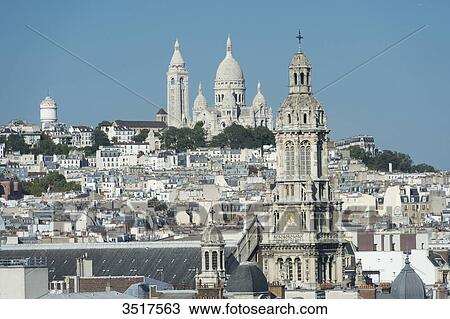 Stock Image - France. Paris 9th district. Bell tower of the Sainte Trinit church and the Sacre-Cur Basilica. Fotosearch