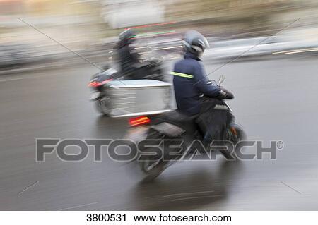 Stock Image - France, Paris, couriers by scooter.. Fotosearch