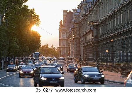 Stock Photo - France, Paris, Quai Francois Mitterrand along the southern wing of the Louvre museum, evening traffic.. Fotosearch