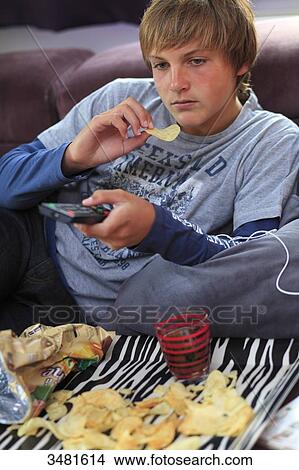 France teenager eating and watching TV View Large Photo Image Picture - France teenager eating and watching TV. Fotosearch