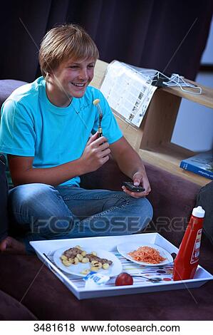 France teenager eating and watching TV View Large Photo Image Stock Photo - France teenager eating and watching TV. Fotosearch