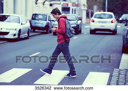 France, teenager walking while using his smartphone View Large Photo Image Stock Image - France, teenager walking while using his smartphone. Fotosearch