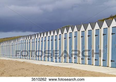 Stock Image - France, Western France, Saint-Gilles-Croix-de-Vie, bathing huts under stormy clouds.. Fotosearch