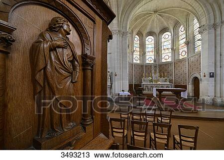 Stock Image - France, Western France, Vendee, Interior view of the Church of the Copechaniere. Wooden sculpture in the foreground. Choir and altar in the background. Fotosearch