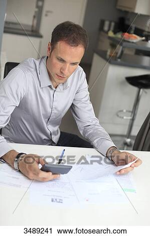 France, young man studying his invoices View Large Photo Image Stock Image - France, young man studying his invoices. Fotosearch