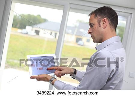 Picture - France, young man with tablet in his home. Fotosearch