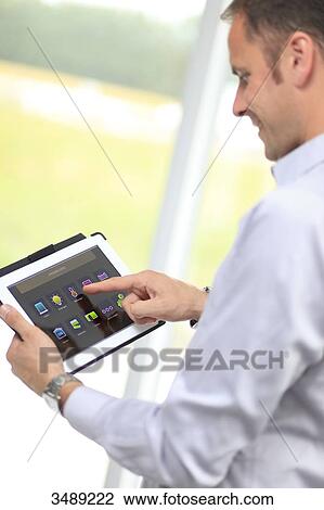 France, young man with tablet in his home View Large Photo Image Stock Image - France, young man with tablet in his home. Fotosearch