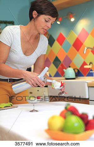 France, young woman in her kitchen preparing a dessert with whipped cream View Large Photo Image Stock Image - France, young woman in her kitchen preparing a dessert with whipped cream. Fotosearch