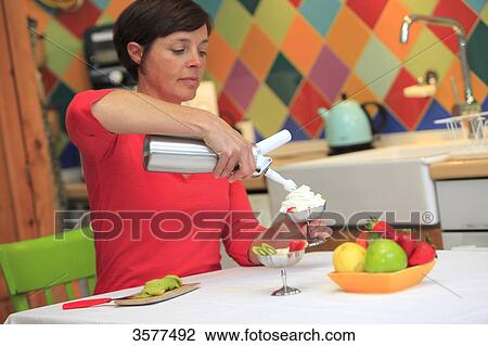 France, young woman in her kitchen preparing a dessert with whipped cream View Large Photo Image Stock Image - France, young woman in her kitchen preparing a dessert with whipped cream. Fotosearch