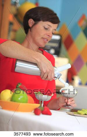 France, young woman in her kitchen preparing a dessert with whipped cream View Large Photo Image Stock Image - France, young woman in her kitchen preparing a dessert with whipped cream. Fotosearch