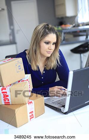 Stock Photography - France, young woman, online shopping. Fotosearch