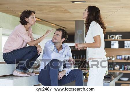 Friends arguing to each other at home View Large Photo Image Stock Photo - Friends arguing to each other at home. Fotosearch