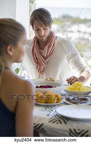 Friends having lunch at a dining table View Large Photo Image Picture - Friends having lunch at a dining table. Fotosearch