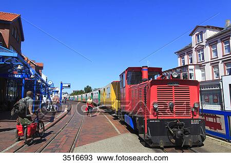 Stock Image - Germany, Lower Saxony. Borkum Island. Railway station, platform and travelers in the middle of the city center. Fotosearch