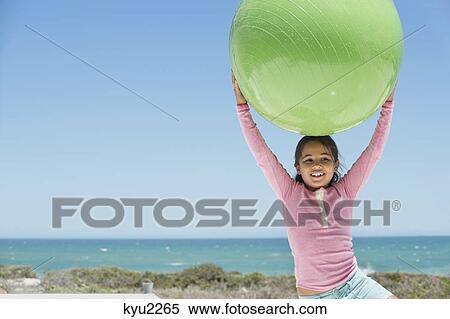 Girl holding a fitness ball on the beach View Large Photo Image Stock Photography - Girl holding a fitness ball on the beach. Fotosearch