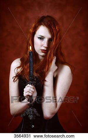 Gothic redhead woman holding a candle View Large Photo Image Stock Image - Gothic redhead woman holding a candle. Fotosearch