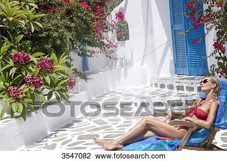 Greece, Cyclades, young woman sunbathing on a deckchair View Large Photo Image Stock Image - Greece, Cyclades, young woman sunbathing on a deckchair. Fotosearch