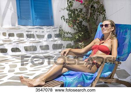Greece, Cyclades, young woman sunbathing on a deckchair View Large Photo Image Stock Photo - Greece, Cyclades, young woman sunbathing on a deckchair. Fotosearch