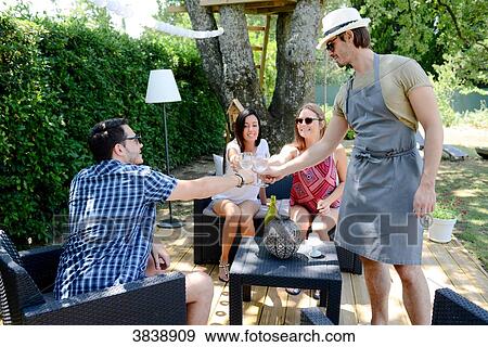 Stock Photo - Group of young and cheerful people having a toast in a garden party outdoor in the backyard during summer holiday.. Fotosearch