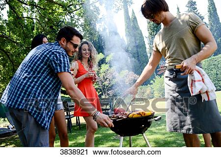Groupe of happy and cheerful young people having fun around barbecue grill during summer holiday party outdoor in the garden. View Large Photo Image Stock Image - Groupe of happy and cheerful young people having fun around barbecue grill during summer holiday party outdoor in the garden.. Fotosearch