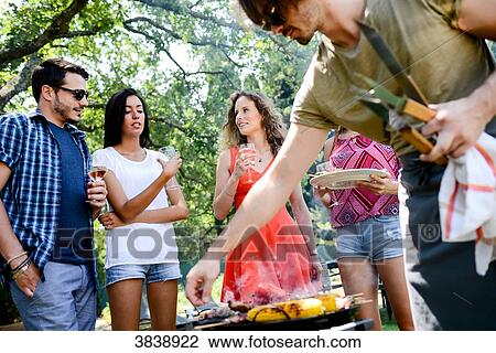 Groupe of happy and cheerful young people having fun around barbecue grill during summer holiday party outdoor in the garden. View Large Photo Image Stock Image - Groupe of happy and cheerful young people having fun around barbecue grill during summer holiday party outdoor in the garden.. Fotosearch